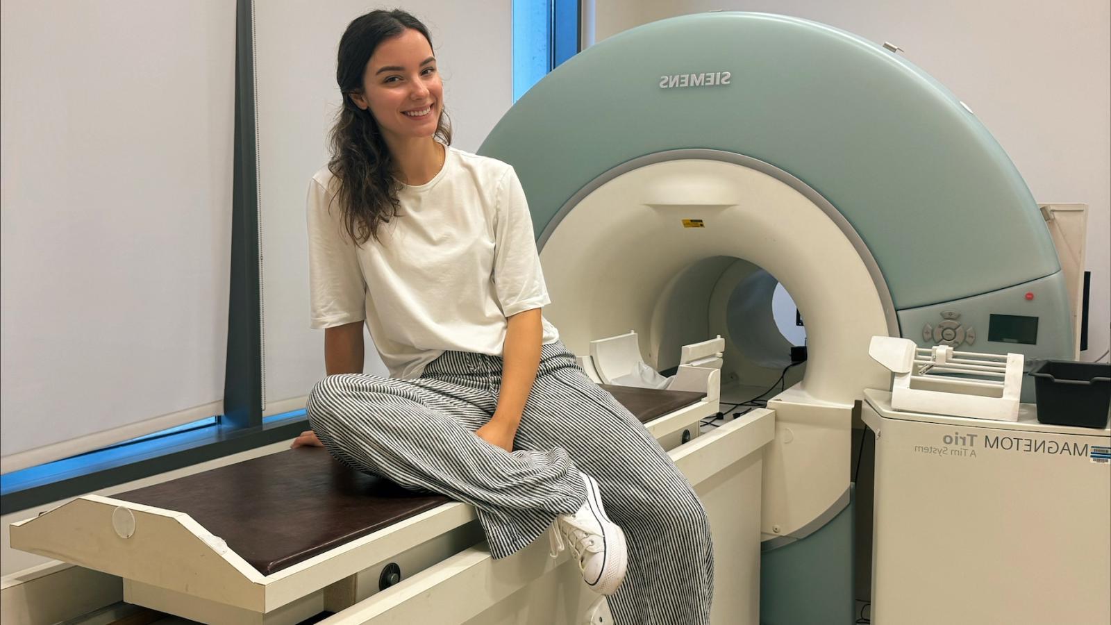 Aiste Abeciunaite seated on fMRI machine in imaging center